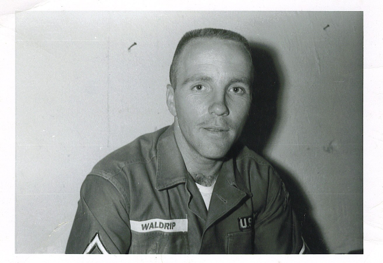 Marvin Waldrip standing beside a military utility vehicle